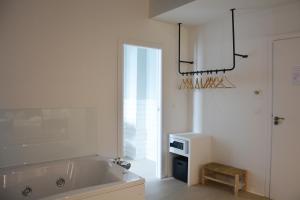 a white bathroom with a tub and a chandelier at YOU & CO. Saler Beach Boutique in Valencia