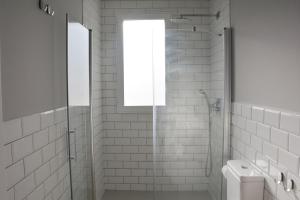 a white bathroom with a shower and a window at YOU & CO. Saler Beach Boutique in Valencia