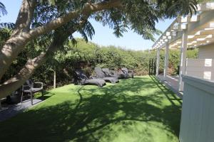 eine Terrasse mit Stühlen und einem Rasenhof in der Unterkunft Lakeside Terrace in Neot Golan