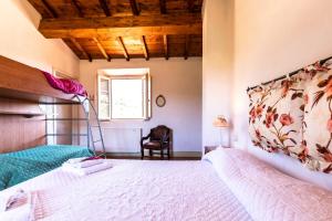 a bedroom with a large bed and a chair at Agriturismo La Mignola in Quercianella