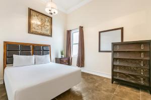 1 dormitorio con 1 cama blanca grande y vestidor en Spacious 4BR Condo on Carondelet Near All Hot Spo, en Nueva Orleans