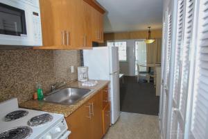 a kitchen with a sink and a white refrigerator at Royal Atlantic Beach Resort in Montauk