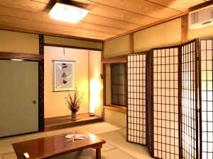 a room with a table and some glass doors at Guest House Zen in Yamanakako