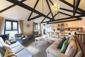 a living room with couches and a dining room at Goonwinnow Farm Cottages in Newquay