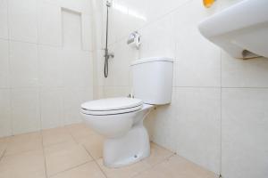 biała łazienka z toaletą i umywalką w obiekcie Arya Graha Semarang w mieście Semarang