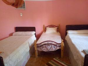 two beds in a room with pink walls at Safari Camp Bahariya Oasis in Bawiti