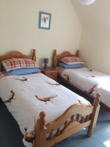 two twin beds in a bedroom with crabprints on the sheets at Lettoch Farm in Dufftown