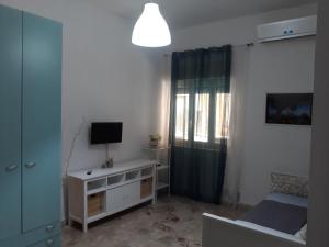 1 dormitorio con 1 cama, TV y ventana en Vacanzasicilia, en Porto Empedocle