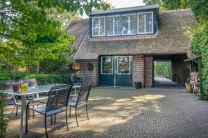 een patio met een tafel en stoelen voor een huis bij Drentse krent in Veeningen