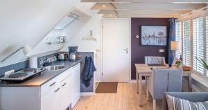 eine Küche mit Spüle und Tisch in einem Zimmer in der Unterkunft Drentse krent in Veeningen