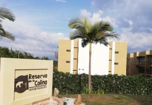 a sign in front of a building with a palm tree at Quindio - Apartasol 207 in La Tebaida