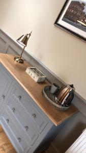 a desk with a lamp on top of a dresser at The Huntingdon in Dumfries