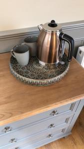 a tea kettle and two cups on a counter at The Huntingdon in Dumfries