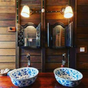 dos lavabos azules y blancos sobre una mesa de madera en tanabendang banglos en Pantai Cenang