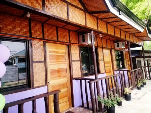 a house with a wooden door and windows at In-N-Out Hostel in Siquijor