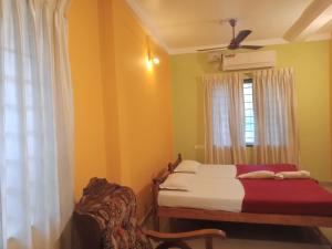 Fort KochiにあるFrangipani Holiday Homeのベッドと窓のある寝室