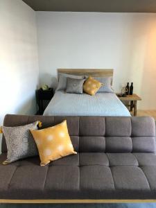 a bedroom with a bed and a couch with pillows at Casa Nican by Barrio Mexico in Guadalajara