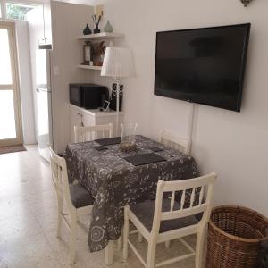 ein Esszimmer mit einem Tisch mit Stühlen und einem TV in der Unterkunft The Summer House in Polis Chrysochous