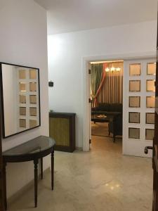 ein Wohnzimmer mit einem Tisch und einem Spiegel in der Unterkunft Nice Furnished apartment in Amman