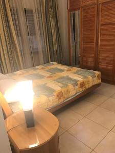 a bed in a room with a table and a lamp at Nice Furnished apartment in Amman