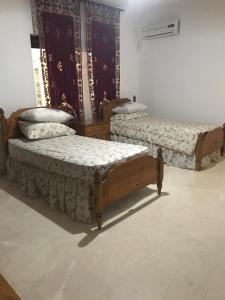 two beds are sitting in a room with at Nice Furnished apartment in Amman