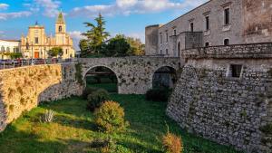 een oude stenen brug met een kasteel op de achtergrond bij ALLEGRETTI'S HOUSE VENOSA, ospitalità e accoglienza in Venosa