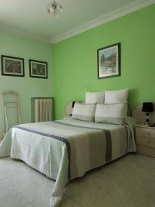 a bedroom with a large bed with green walls at Hotel Fray Juán Gil in Arévalo