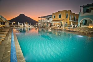 a large swimming pool with a mountain in the background at Elena Village in Kalymnos