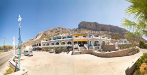 a building on a street with a mountain in the background at Elena Village in Kalymnos