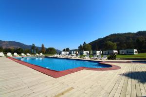 una piscina con sillas, mesas y una montaña en Achibueno Lodge en Linares