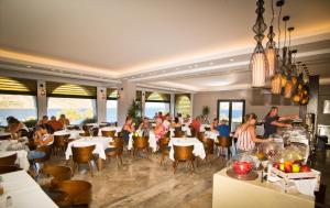 eine Gruppe von Personen, die in einem Restaurant an Tischen sitzen in der Unterkunft Elena Village in Kalymnos