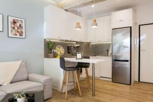 a kitchen and living room with a table and a refrigerator at Disinffected Kifissia Central near Metro Apartment 1BR in Athens