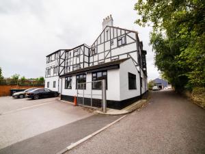 a white and black building with a parking lot at OYO The Royal Hotel in Newcastle upon Tyne