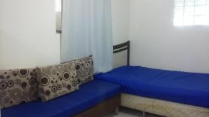 een kleine slaapkamer met een blauw bed en een raam bij Sonhos de sereia in Ponta da Fruta