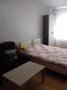 ヴェリーキー・ノヴゴロドにあるTimura Frunze-Olovyanka Apartmentのベッドルーム1室(ベッド1台、ソファ、テーブル付)