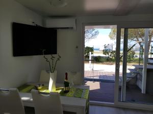 a dining room with a table and a television on the wall at Matorin Floatinghouses in Portorož