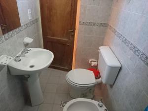 a small bathroom with a toilet and a sink at Sumaq Samay in San Antonio de los Cobres