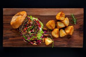 een houten snijplank met een salade en brood bij De Kombuys in Oudtshoorn