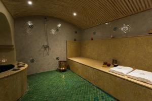 a bathroom with a shower and a tub with towels at RIAD AZRUR in Marrakech