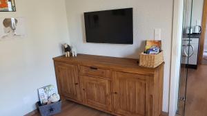 a television on a wall with a wooden cabinet at Ferienwohnung Eichelgasse Wertheim in Wertheim