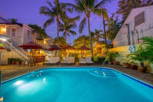 a swimming pool at night with chairs and umbrellas at Duval Inn - Key West in Key West