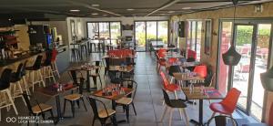 a restaurant with tables and chairs in a room at Kyriad Lille - Roncq in Roncq