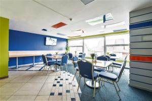 سبورت هوتل في ليبايا: غرفة طعام مع طاولات وكراسي وجدران زرقاء