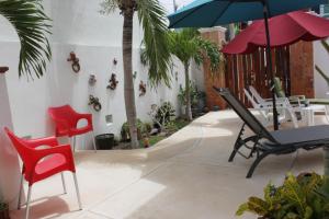 un patio con sillas y una mesa con sombrilla en Villas Keh, en Isla Mujeres