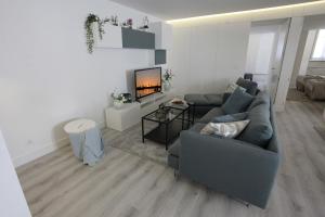 salon z kanapą i kominkiem w obiekcie Apartamento das Malheiras w mieście Viana do Castelo