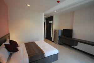 a bedroom with a bed and a flat screen tv at Baan Mina in Bangkok