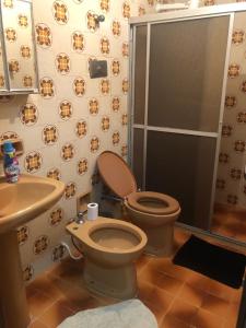 uma casa de banho com um WC, um lavatório e um chuveiro em Propriedade aconchego de família em Salvador