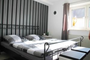 ein Bett in einem Schlafzimmer mit einer schwarz gestreiften Wand in der Unterkunft Ferienwohnung Ferienliebe Lahn Dill in Hochelheim