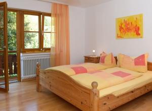 a bedroom with a large wooden bed with colorful pillows at Bergfranzenhof in Oppenau