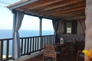 balcón con mesa, sillas y vistas al océano en Terraza del Atlántico en Playa de Santiago